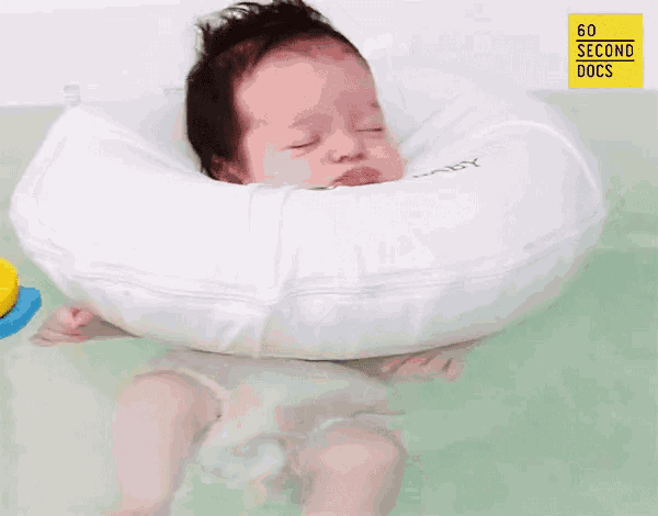 a baby is laying in a bathtub with a white float around his neck