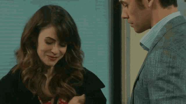 a man and a woman are looking at each other and the woman is smiling