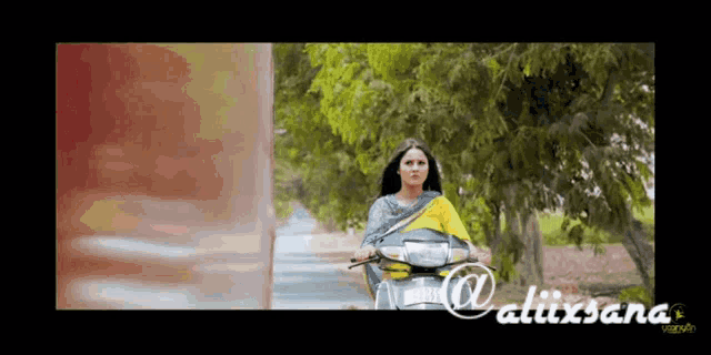 a woman is riding a scooter down a road and the words alixsana are on the bottom of the screen