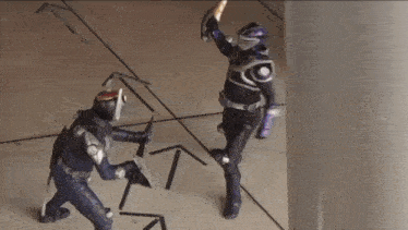 two superheros are fighting with swords on a tiled floor