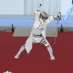 a man in a fencing uniform is kneeling down on the floor