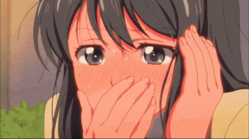 a girl is covering her mouth with her hands while looking at the camera