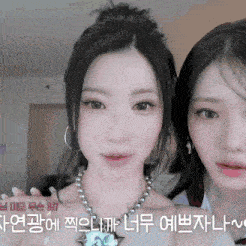 two girls are standing next to each other and one has a necklace on