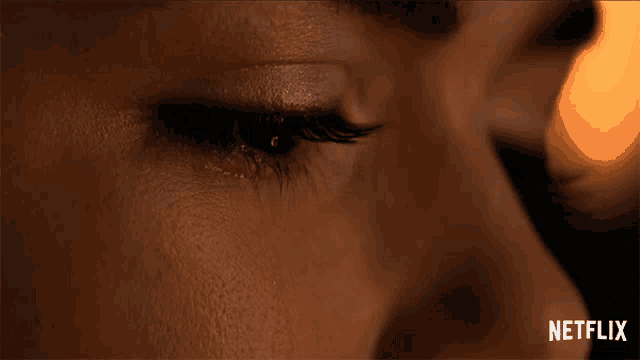 a close up of a woman 's eye with a netflix logo behind her