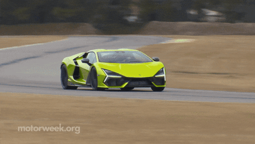 a yellow sports car is driving down a road with motorweek.org written on the bottom right