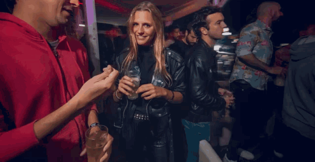 a woman in a white leather jacket is dancing with another woman in a black leather jacket