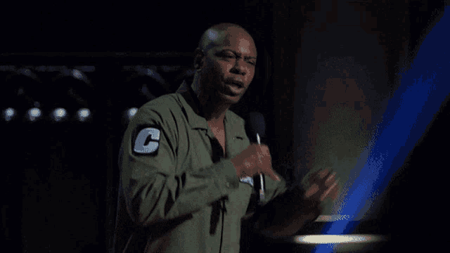 a man in a green shirt with a patch that says c on it