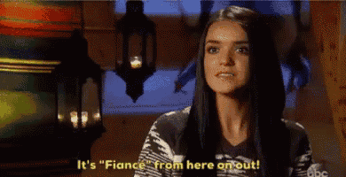 a woman is standing in front of a lantern and saying it 's fiance from here on out .