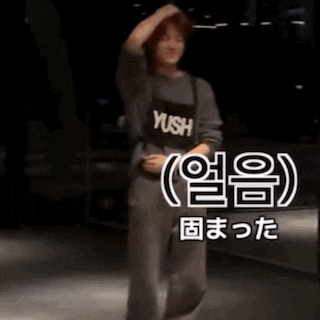 a blurry picture of a person dancing in a dark room with chinese writing on the bottom .