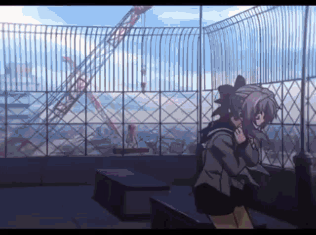 a girl is sitting on a bench in front of a fence