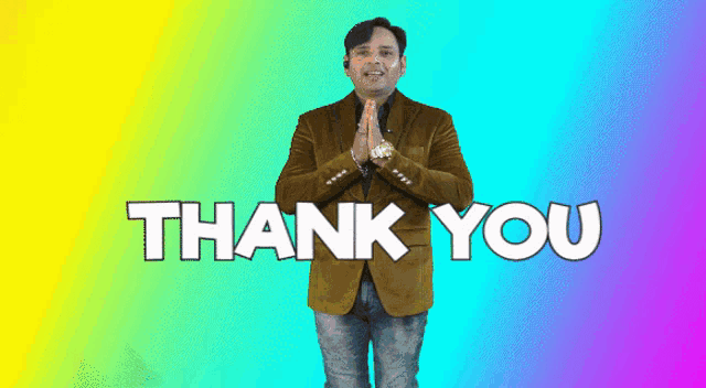 a man in a brown jacket stands in front of a colorful background and says thank you