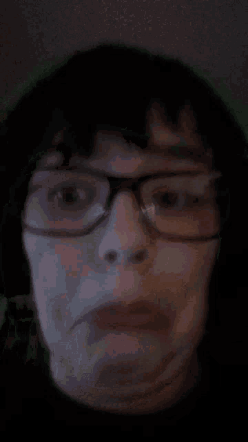 a close up of a person wearing glasses and a black shirt