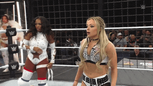 two female wrestlers in a ring with a w logo on the side