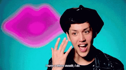 a man wearing a beret and a leather jacket is waving his hand in front of a pink lips behind him .