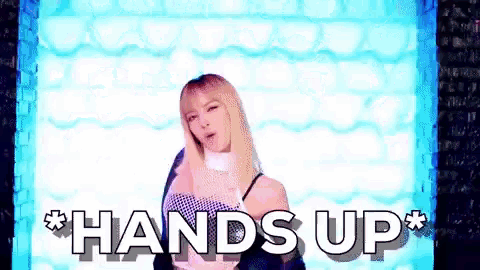 a woman is standing in front of a wall with the words hands up on it