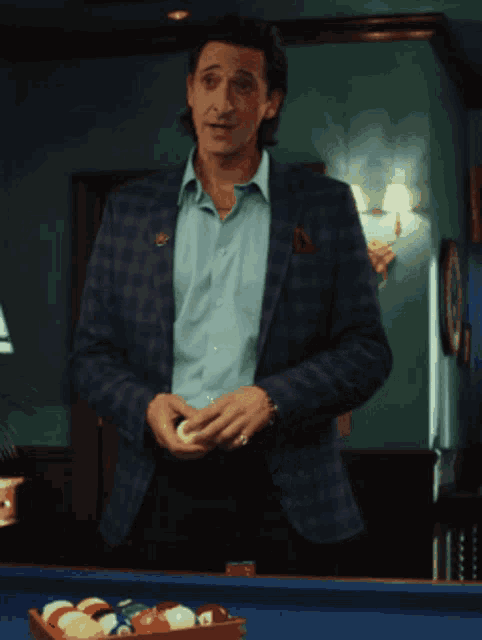 a man standing in front of a pool table with chips