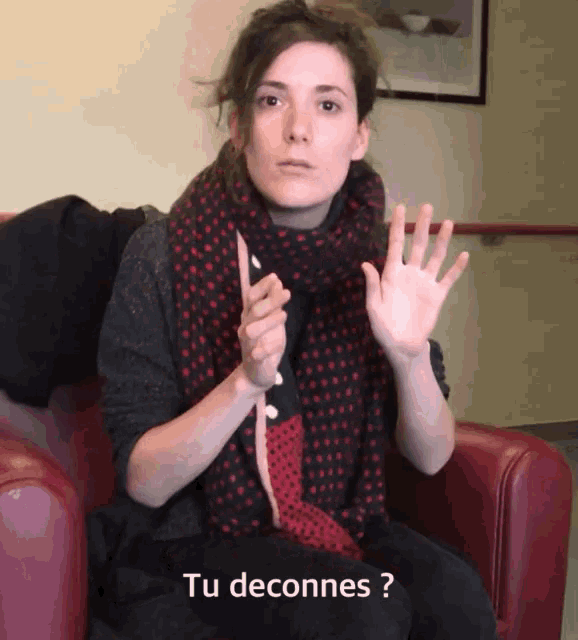 a woman wearing a scarf is sitting in a chair with the words tu deconnes on the bottom
