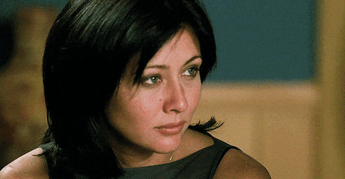 a close up of a woman 's face with a necklace on her neck