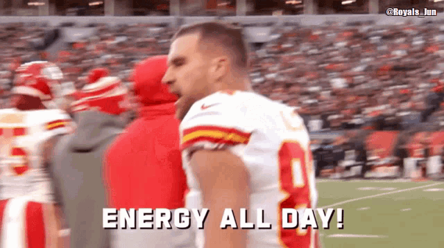 a football player says " energy all day " in front of a crowd
