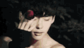 a close up of a woman 's face with a flower in her hair