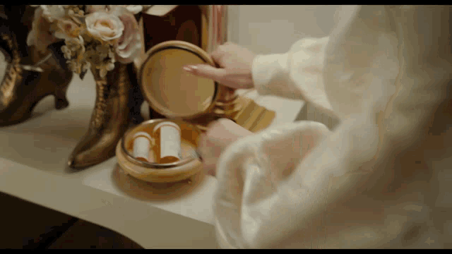 a woman is taking pills out of a container on a table