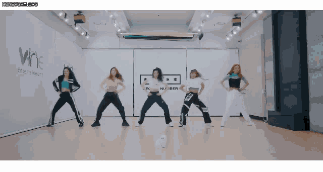 a group of girls are dancing in front of a wall that says wine