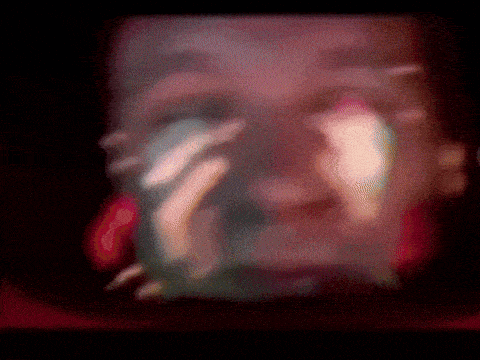 a blurry picture of a person 's face with their hand on their face