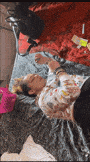 a woman is laying on a bed with a pink basket nearby