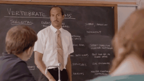 a man stands in front of a chalkboard that says vertebrate