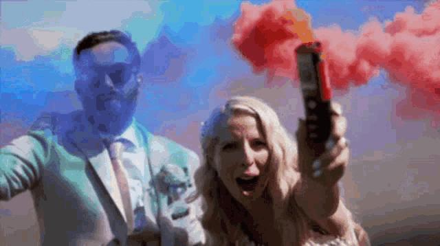 a bride and groom are holding smoke bombs in their hands .