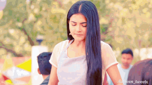 a woman with long black hair is standing in front of a blurry background with the hashtag adiveen tweetx