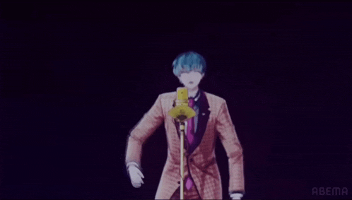 a man in a suit is standing in front of a microphone in a dark room .