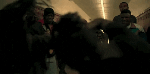 a group of young people are standing in a hallway .