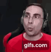 a man wearing headphones is making a surprised face .
