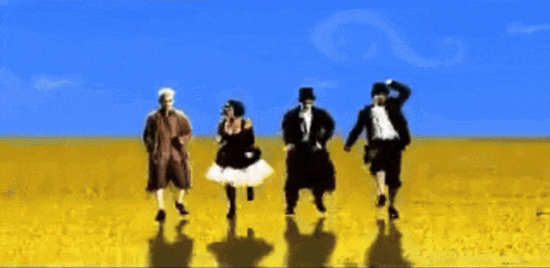 a group of people dancing in a field with a blue sky behind them