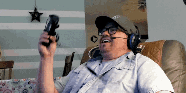 a man wearing a hat and headphones holds a game controller