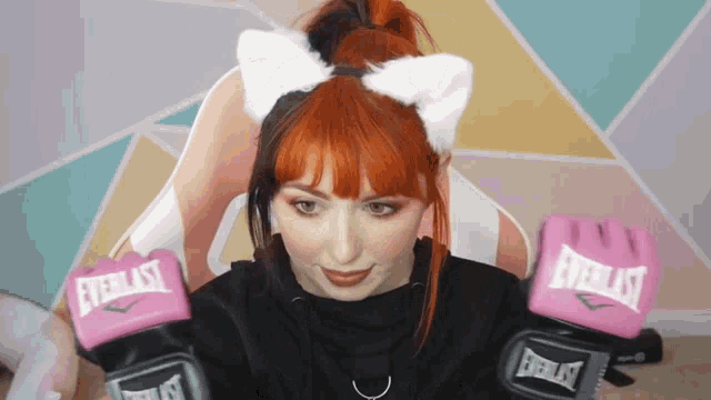 a woman is wearing everlast boxing gloves and a cat ear headband