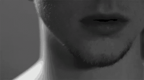 a black and white photo of a man 's face with a beard