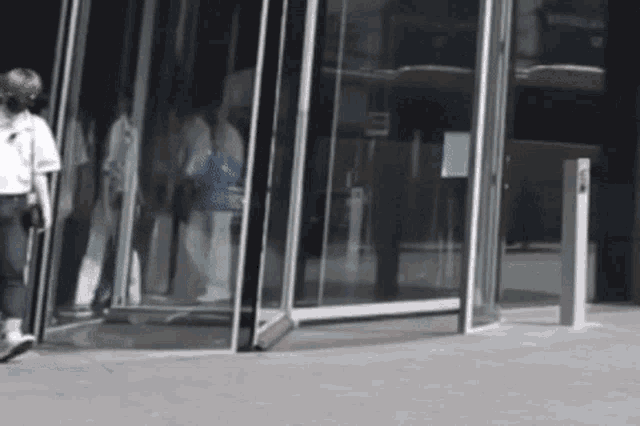 a woman walking in front of a revolving door