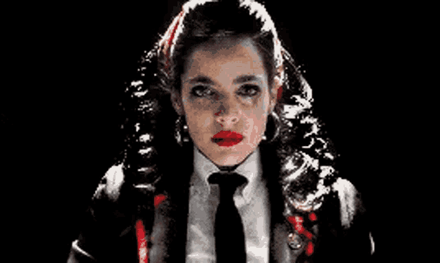 a woman in a suit and tie with blood on her face .