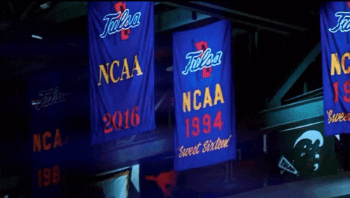 three ncaa banners hanging from a ceiling
