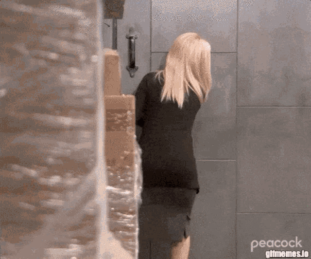 a woman in a black dress is standing in front of a door in a room .