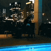 a blurry picture of a city at night with a pool in the foreground and the number 21 in the background