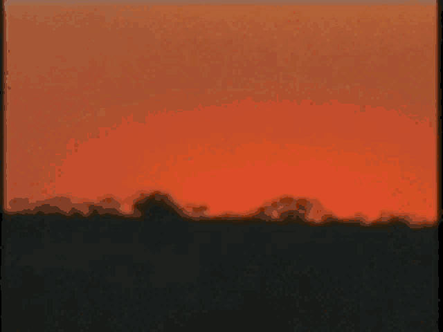 a close up of a sunset with the sun shining through the clouds .