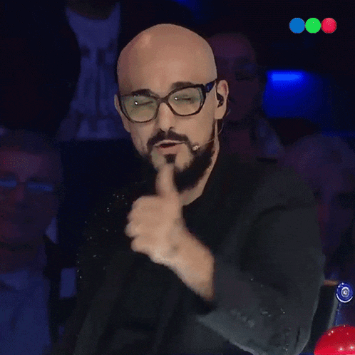 a bald man with glasses and a beard is giving a thumbs up sign