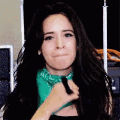 a woman wearing a green bandana is making a funny face .