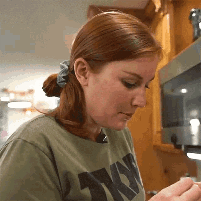 a woman wearing a green shirt that says army