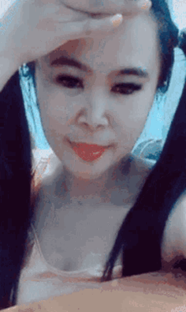 a woman covering her face with her hand and smiling