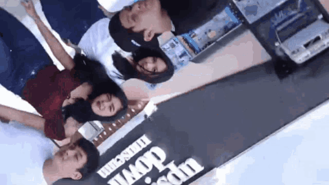 a group of people are posing for a picture with a sign that says upside down