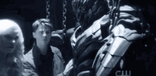 a man and a woman are standing next to a statue of a robot .